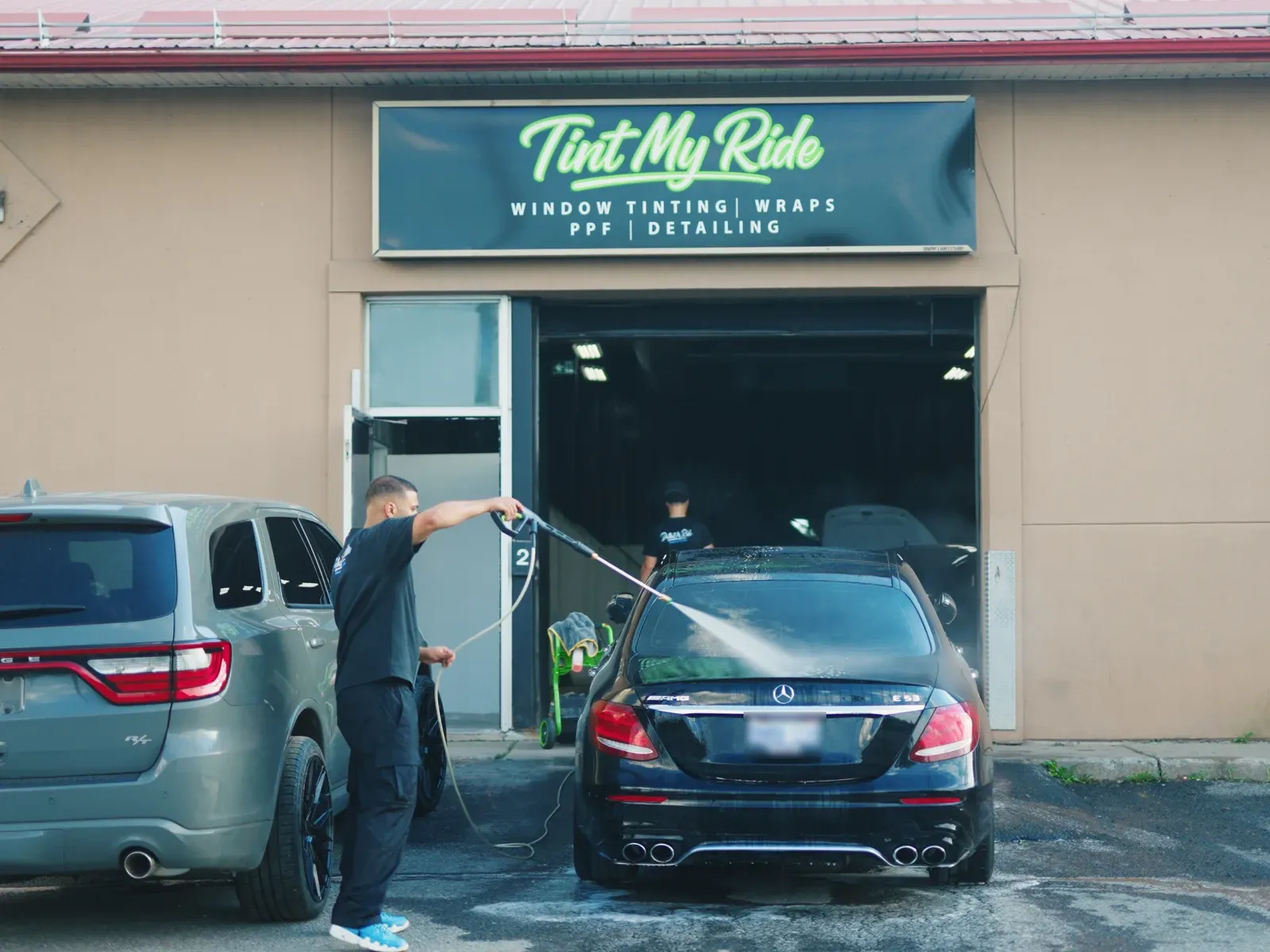 Tint My Ride technician washing a vehicle outside the Hawthorne Road shop